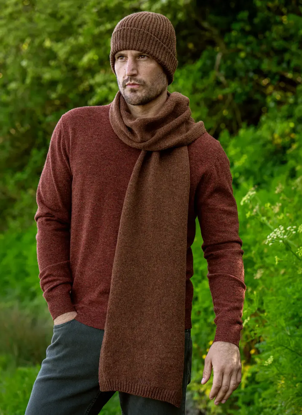 Personalized wool cashmere scarf in chestnut brown, made in Ireland, worn with rust sweater in forest backdrop